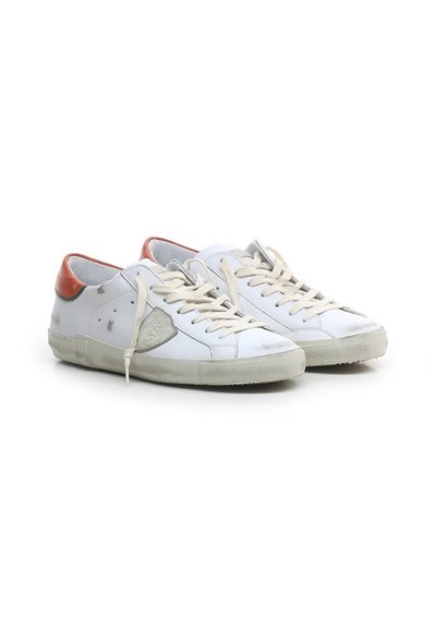 Sneakers bianchi in pelle con un pannello in suede grigio, accentuazione rossa sul tallone, lacci beige e suola in gomma consumata. Design a profilo basso con punta arrotondata.