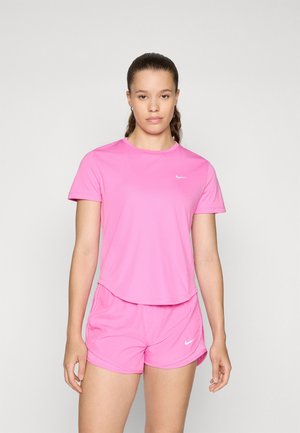 T-shirt et short de sport roses en tissu léger et lisse ; présentent un logo Nike blanc sur la poitrine et sur le côté du short.
