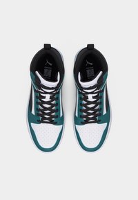 Ζευγάρι λευκών και τυρκουάζ ψηλών αθλητικών παπουτσιών με μαύρα κορδόνια, σε θέα από πάνω, σε απλό ανοιχτό φόντο.