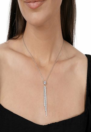 Sølv halskæde med en rund vedhæng og faldende strenge af små krystaller, der skaber et lineært design. Kæde med lukket lås.