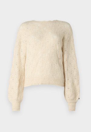 Gräddfärgad stickad tröja med ett strukturerat diamantmönster, långa puffärmar och ribbstickade manschetter. Den korta designen ger en modern känsla.