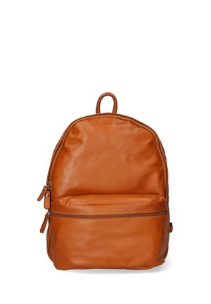 Sac à dos en cuir marron avec une forme arrondie, une poignée supérieure et une poche zippée à l'avant. Texture lisse et design minimaliste.