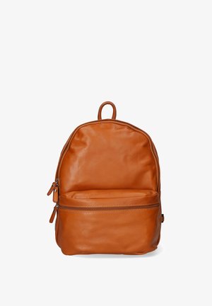 Sac à dos en cuir marron avec une forme arrondie, une poignée supérieure et une poche zippée à l'avant. Texture lisse et design minimaliste.