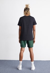 Nike Sportswear FLOW - Pantaloni sportivi - fir
