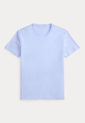 T-shirt bleu clair à manches courtes et col rond avec petit logo rose brodé sur le côté gauche de la poitrine, posé à plat sur fond blanc.