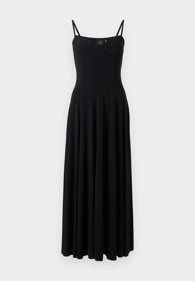 Juoda maksi suknelė su plonais reguliuojamais petnešėlėmis, prigludusia liemene ir išplečiamu sijonu, pagaminta iš tamprus audinio. Yra sklandus paviršius.