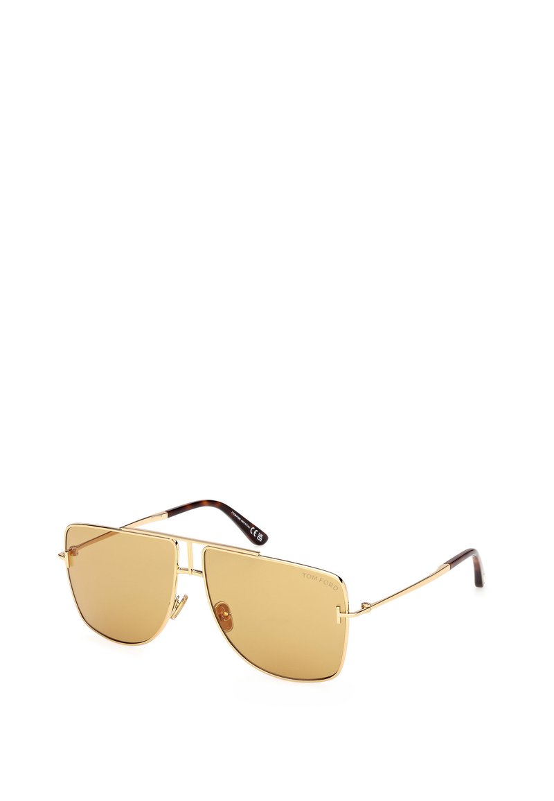 Guldmetallsolglasögon med amberlins, vinkelruta, tunna armar och bruna acetattips. Har en minimalistisk design och inarbetad logotyp.