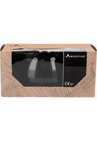 L'emballage du produit Whistler présente une fenêtre transparente mettant en valeur un article noir à l'intérieur, installé contre une boîte en carton marron à motifs.