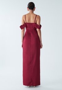 Burgunderfarbene Satin-Abendkleid mit schulterfreiem, gefälteltem Design, tailliertem Oberteil und einem langen, fließenden Rock. Reißverschlussverschluss auf der Rückseite.