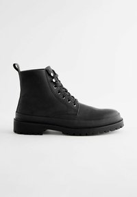 Botín negro de cuero, con suela de goma resistente, diseño de cordones, tira de agarre y textura suave con ojales de metal.