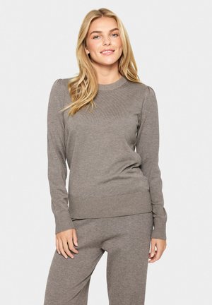 Light brown knit sweater with long sleeves, ribbed cuffs and hem, featuring a round neckline and a textured surface.
