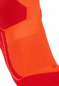 Calzino rosso brillante e arancione con un design testurizzato, realizzato in tessuto liscio e con punta rinforzata. Include marker di dimensione "R" per il piede destro.