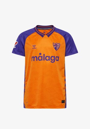 Orange tröja med lila ärmar, med texten "málaga" och en klubbemblem. Den har ett geometriskt mönster och en rund halsringning.