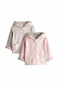 Dve detské mikiny na zips: jedna s kvetinovým vzorom, ružovým srdcom; druhá pruhovaná ružová s výšivkou zajaca a kvetinovou lemovkou.