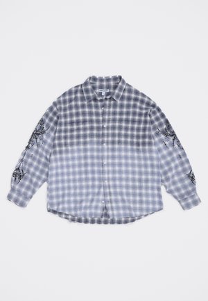 Pika varrukaga sinine ja valge ruuduline flanellsärk, millel on nööbi esikülg ja mõlemal varrukal mustad abstraktsed graafikud.