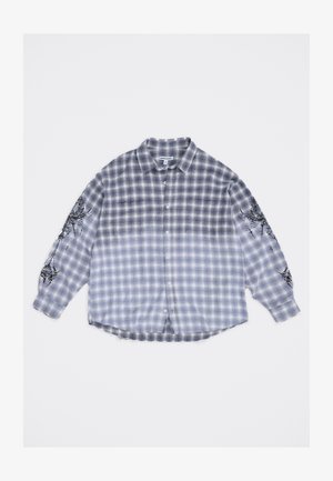 Pika varrukaga sinine ja valge ruuduline flanellsärk, millel on nööbi esikülg ja mõlemal varrukal mustad abstraktsed graafikud.