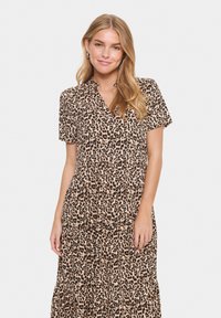 Kjol med leopardmönster, kort ärm, V-ringning, rynkad midja och lager på lager-skirt. Tillverkad i ett lätt tyg med en mjuk textur.