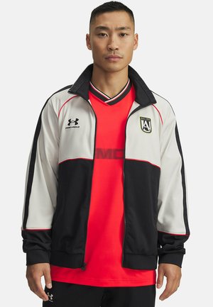 Black, white, and red zip-up jacket with a standing collar; features brand logo on the chest and contrasting color panels on sleeves.
