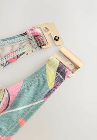 Daudzkrāsaini auduma siksnas ar ziedu rakstiem, ar zelta metāla detaļām un spiedpogu aizdari. Gluda tekstūra ar detalizētu šuvumu.