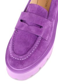 Mocassino in suede viola con una larga fascia, cuciture bianche a contrasto e una spessa suola in gomma viola. Finitura testurizzata sulla tomaia.