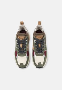 Baskets en vert, crème et bordeaux avec une tige en suède et cuir. Dotées d'une semelle épaisse, d'une languette rembourrée et de lacets contrastants.