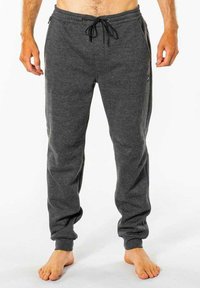 Grå sweatpants lavet af blødt stof, med en elastisk talje med snøre, ribbede ankler og sidelommer.