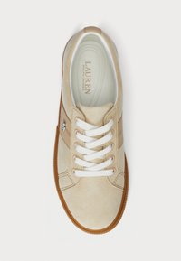 Beige suede sneaker with white laces, a gum rubber sole, and side stripes. Features "Lauren Ralph Lauren" logo on the tongue.