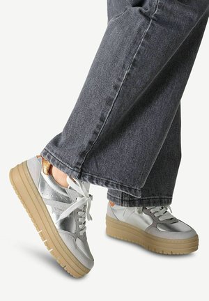 Sneaker in materiali misti argentati con suola beige a strati e lacci bianchi. Presentano un sottile accento marrone vicino al tallone.