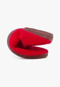 Rode instapschoen met een textiel bovenkant en een zachte binnenkant, voorzien van een flexibele bruine rubberen zool en een minimalistisch ontwerp.