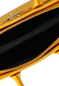 Borsa a mano in pelle gialla con chiusura dorata, aperta per mostrare l'interno in tessuto nero e un compartimento centrale con zip.