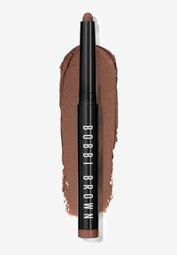 Bobbi Brown läpppenna i en stilren svart förpackning, med en rundad, mjuk brun spetts och en texturerad krämig färgprov bredvid.