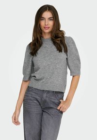 Gray knitted sweater with short puff sleeves, featuring decorative pearls scattered across the front, worn with dark gray denim jeans.