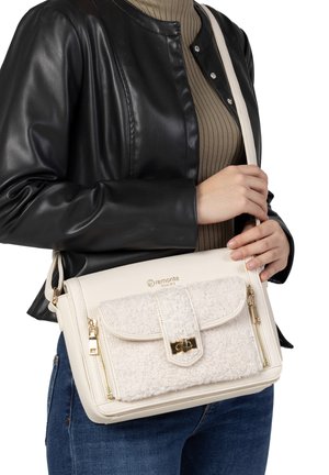 Weiße Handtasche mit einem strukturierten cremefarbenen Überschlag, goldenen Beschlägen und Reißverschlüssen. Aus synthetischem Material gefertigt, verfügt sie über einen langen verstellbaren Trageriemen.