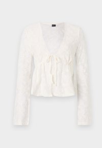 Weiße Bluse mit langen Ärmeln und tiefem V-Ausschnitt, Bindeband-Detail vorne, florales Spitzenmuster und peplumförmigem Saum. Weicher, transparenter Stoff.