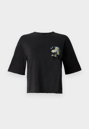 Musta lyhythihainen crop-top-paita, jossa on pyöreä pääntie, ja jossa on kukkakirjontaa sekä teksti "LE JARDIN de la" edessä.