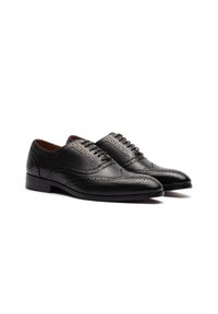 Chaussures de ville en cuir noir avec des détails en brogue, bout pointu et laçage standard. Texture lisse avec un design solide et des accents minimaux.