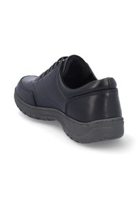 Zapatilla negra de cuero con suela texturizada y cuello acolchado, que presenta una forma redondeada, seis ojales para los cordones y un talón sin costuras.