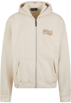 Krémová zipová mikina s kapucňou má kengurské vrecko, rebrové manžety a hnedo vyšitý logo na ľavej hrudi. Mäkký bavlnený materiál.