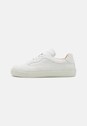 Hvit lær sneaker med rund tå, flate lisser, polstret tunge og teksturert mellomsåle. Har en glatt finish og minimal design.