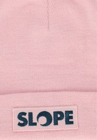 Vaaleanpunainen neulepipo, jossa on käännetty reuna ja ommeltu etiketti, jossa lukee "SLOPE" tummansinisellä, valmistettu pehmeästä, teksturoidusta kankaasta.