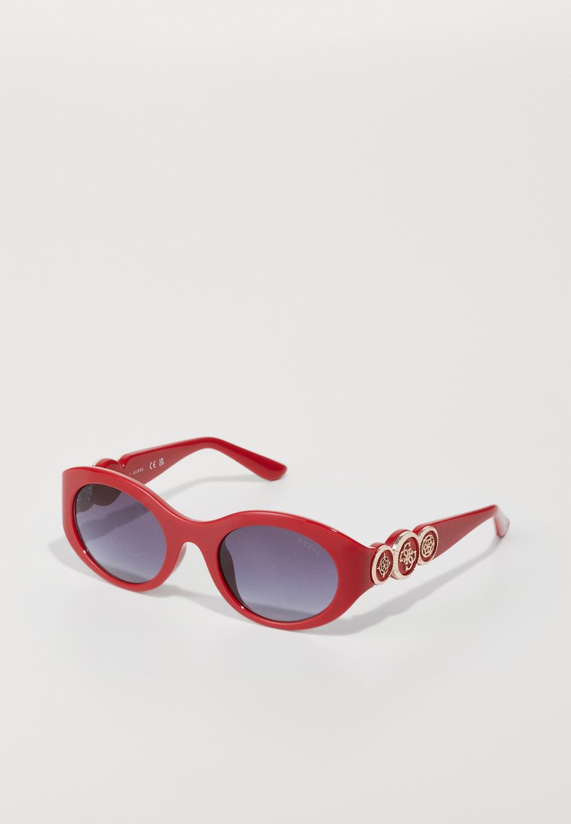 Red plastic sunglasses with oval lenses, gradient from dark to light purple, featuring metal accents with circular designs on the temples.