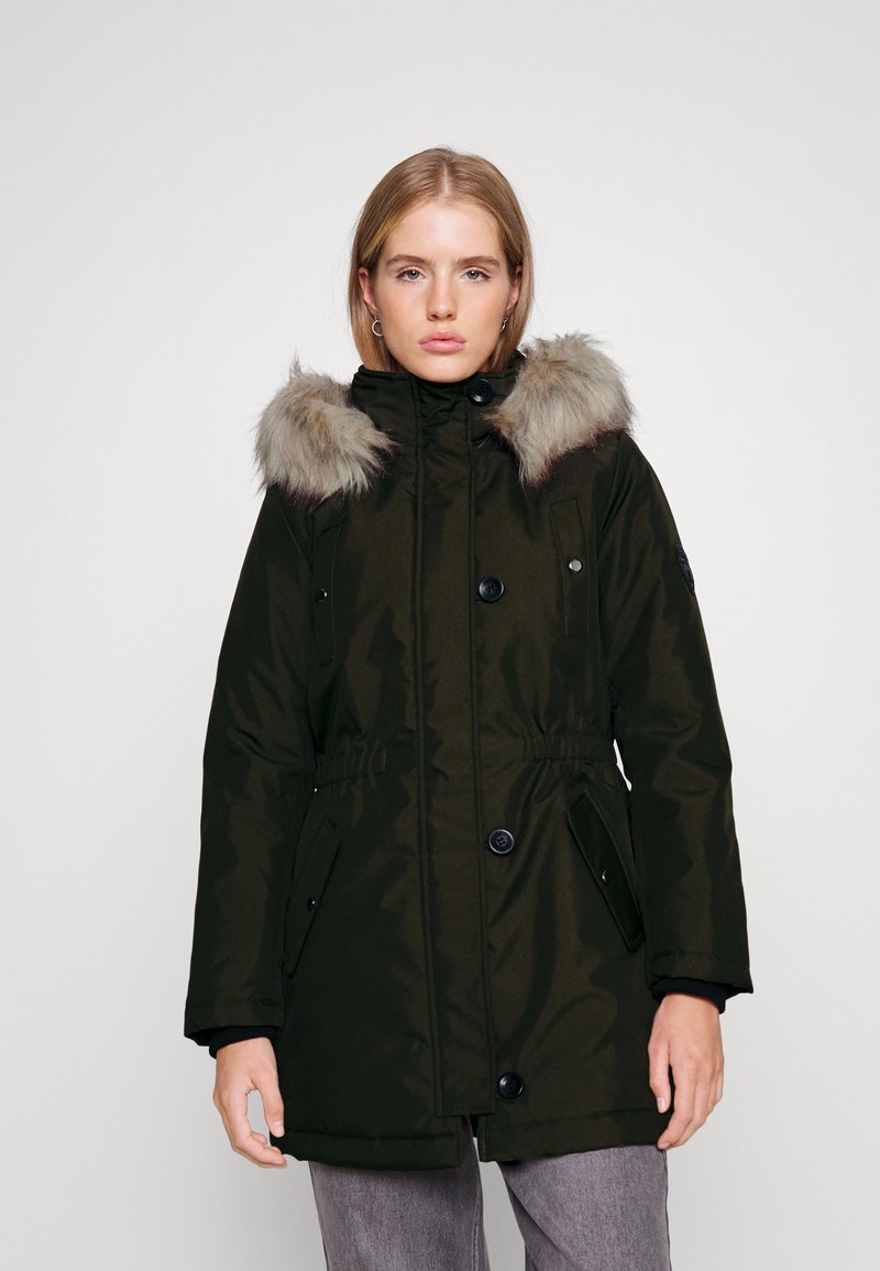 Parka verde oliva con bordo in pelliccia sintetica, chiusura a bottoni, tasche laterali e vita elasticizzata per una vestibilità regolabile.