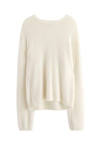 Pull crème en tissu moelleux, avec un col rond, des épaules tombantes et des manches longues avec des poignets côtelés.