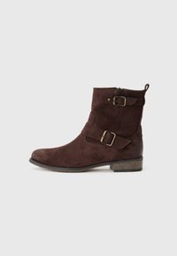 Bottines en suède marron avec un bout rond, une fermeture éclair sur le côté, deux sangles décoratives avec boucles et un petit talon empilé.
