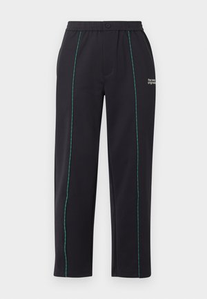 Mustad elastse vöökohaga püksid siniste vertikaalõmblustega ja väikese valge "the new originals" tekstiga parema ülejala ülaosas.