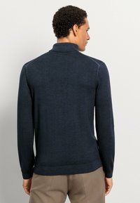Dunkelblauer Pullover aus weichem Stoff, mit langen Ärmeln und hohem Kragen, mit einem gerippten Saum und Bündchen, von hinten gezeigt.