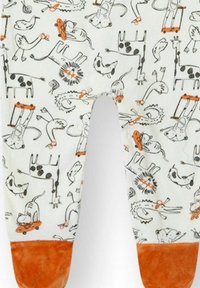 Tela blanca con estampado de ilustraciones de animales negras y acentos naranjas; cuenta con puños suaves de felpa marrón en la parte inferior.