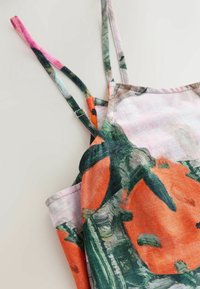 Šaty na tenkých ramienkach s abstraktným kvetinovým vzorom v oranžovej, zelenej a ružovej farbe na svetlom materiáli s voľným strihom.