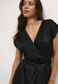 Schwarzes Wickelkleid mit kurzen Ärmeln, strukturiertem Stoff, V-Ausschnitt und einem gebundenen Taillengürtel. Einfaches und elegantes Design.