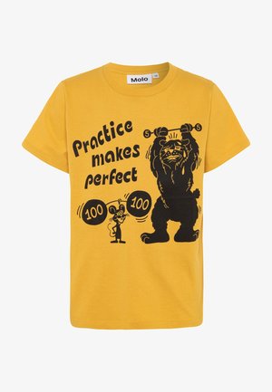 Camiseta infantil amarilla con texto negro "La práctica hace al maestro" y una caricatura de un ratón levantando pesas de 100 libras y un perro luchando con pesas de 5 libras.